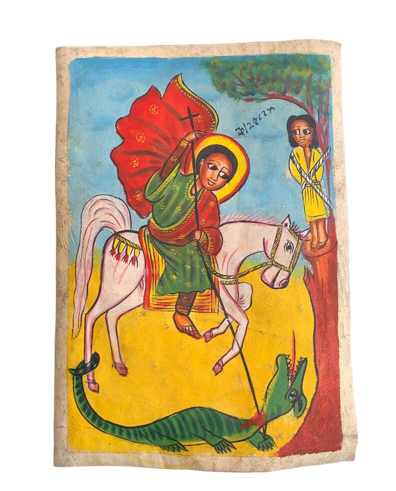 以下が含まれることがあります： 手描きのエチオピアのイコン。緑のドラゴンを殺す馬に乗った聖人が描かれています。聖人は赤と緑のローブを着ており、ハローがあります。黄色の人物が近くに立っています。背景は黄色、青、赤です。