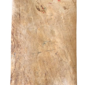 以下が含まれることがあります： 薄茶色の長方形の、古びた質感の紙。紙には折り目やシミが目立ち、赤と緑の小さなペイントの跡がある。端はわずかにカールしており、古さと使用感を示唆している。