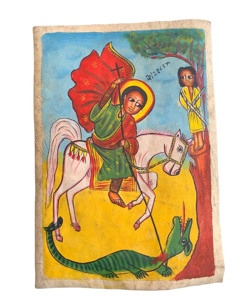 以下が含まれることがあります： 手描きのエチオピアのイコン。白い馬に乗った人物が緑のドラゴンを倒している様子が描かれています。その人物は赤いマントと緑のチュニックを着ています。黄色い服を着た人が木に縛られています。背景は黄色と青です。