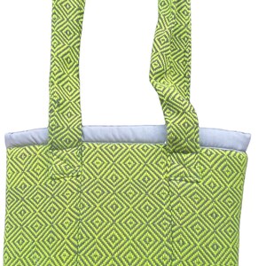 Puede incluir: Una bolsa de mano verde y gris con un patr&oacute;n de diamantes. La bolsa tiene dos asas y un fondo plano.