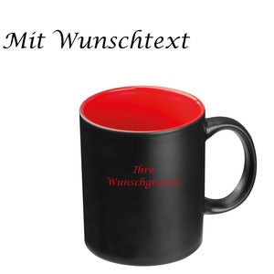 Könnte beinhalten: Schwarze Keramik-Tasse mit roter Innenseite. Die Tasse hat einen gebogenen Henkel und den Text "Ihre Wunschgravur" in Rot. Die Worte "Mit Wunschtext" stehen über der Tasse.