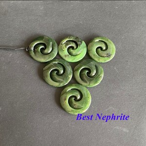 May include: Seven green jade pendants with a spiral design, known as a Maori Koru, arranged in a triangular shape. The pendants are made of nephrite jade and have a smooth, polished finish. The text "Best Nephrite" is visible at the bottom of the image.