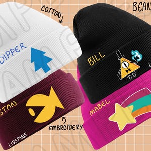 May include: Four knitted beanies with embroidered designs. The beanies are white, black, maroon, and pink. The designs include a pine tree, a triangle with an eye, a fish, and a shooting star. The beanies are labelled "Dipper", "Bill", "Stan", and "Mabel".