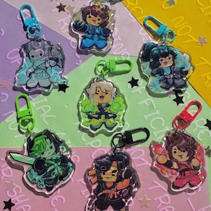 May include: Seven acrylic keychains featuring cartoon characters in various coloured outfits, including blue, green, black, and red, each attached to a matching plastic lobster clasp. The characters display dynamic poses with elemental effects.
