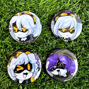 Puede incluir: Cuatro pines redondos con botón que presentan personajes de dibujos animados con cabello morado y blanco, ojos negros y detalles amarillos. Los personajes visten ropa negra y tienen diferentes expresiones faciales.
