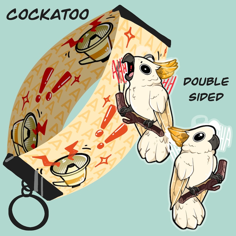 May include: Double-sided Cockatoo design on a yellow and white lanyard with a red exclamation point pattern. The lanyard has a black metal clip and a silver key ring. The Cockatoo is white with a yellow crest and is shown with its mouth open as if it is screaming.
