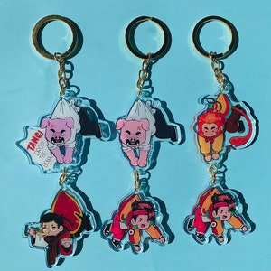 Puede incluir: Tres llaveros de oro con dijes de personajes de dibujos animados. El primer llavero tiene un cerdo rosa con un gorro de chef rojo y blanco y sosteniendo un tazón. El segundo llavero tiene un cerdo rosa con un gorro de chef rojo y blanco y sosteniendo un tazón. El tercer llavero tiene un mono con un gorro de chef rojo y blanco y sosteniendo un tazón. El texto en el primer llavero dice "Tang! Drop the bowl!"