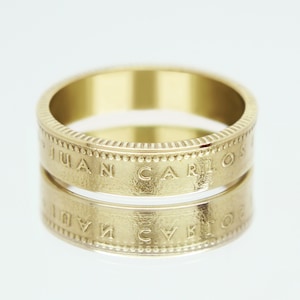 Peut inclure: Une bague en or avec l'inscription "JUAN CARLOS" gravée sur la bande.