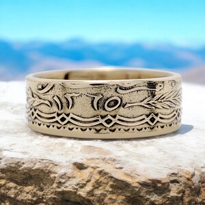 Op de afbeelding: Een gouden ring gemaakt van een hergebruikte munt. De ring heeft een gedetailleerd ontwerp met een tarwehalm en het woord "ITO" zichtbaar op de band.