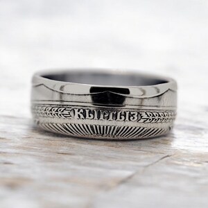 May include: A silver ring made from a coin with the word "Kyrgyz" inscribed on it.
