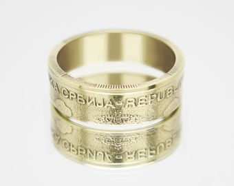 May include: A gold ring made from two stacked Serbian Dinar coins. The coins feature the text "Republika Srbija" and a coat of arms.