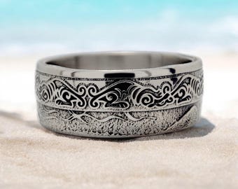 Può includere: Un anello d'argento con una superficie testurizzata e un design intricato di onde e volute.
