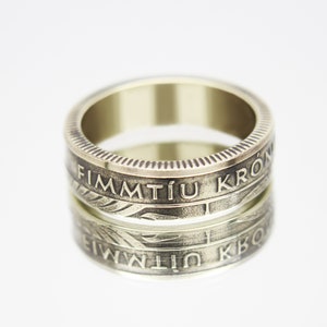 Könnte beinhalten: Ein goldfarbener Ring aus einer finnischen Vintage-Münze. Der Ring trägt die Inschrift "FIMMTÍU KRÓN" um das Band.