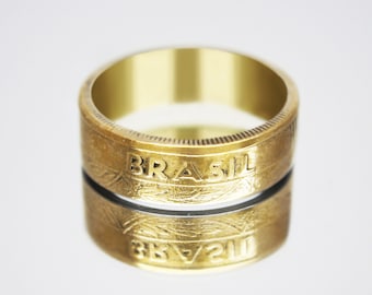 May include: A gold ring made from a Brazilian coin. The ring features the word "BRASIL" engraved on the top and the inscription "3K/21W" on the bottom.