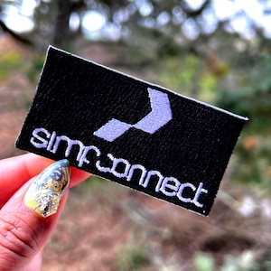 May include: A black embroidered patch with a white chevron design and the text "simp connect" in white.
