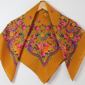 May include: A mustard yellow square scarf with a floral pattern in shades of pink, orange, purple, and green.