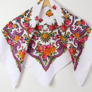 May include: White cotton scarf with a paisley pattern in shades of pink, orange, yellow, and blue.