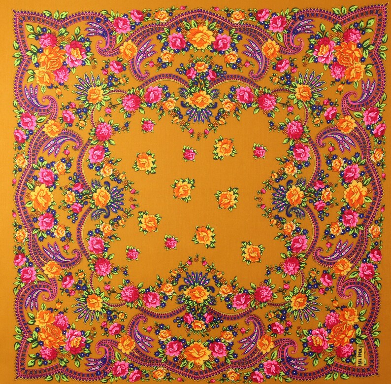 May include: A square, mustard yellow fabric with a floral pattern. The pattern features pink, yellow, and orange flowers with green leaves. The fabric has a paisley design with a dark blue outline.