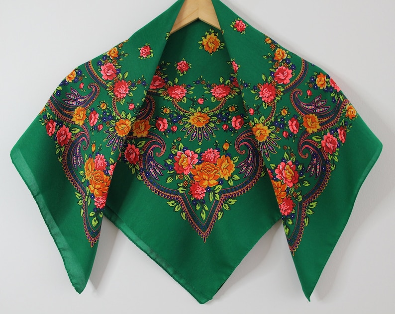 May include: A green paisley patterned headscarf with a floral design in shades of orange, pink, and red.