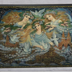 May include: A hand-painted wooden box with a scene of three women with long flowing hair and white doves flying around them. The women are wearing floral crowns and flowing white dresses. The background is a dark blue sky with clouds and a city skyline.