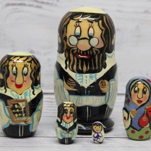 May include: Set of five traditional Russian nesting dolls, or matryoshka dolls. The largest doll is a man with a beard and glasses, wearing a black and white outfit. The other dolls are a woman with a calculator, a woman with a blue dress, a woman with a black dress, and a small woman with a blue dress.