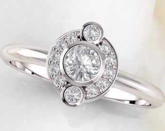 May include: A silver ring with a large round diamond surrounded by smaller diamonds. The ring has three smaller diamonds on the side.