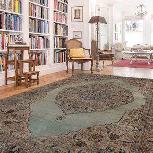 Pu&ograve; includere: Un tappeto a motivi blu chiaro e marrone con un grande e intricato disegno floreale al centro. Il tappeto &egrave; steso su un pavimento in legno in una stanza con pareti bianche e librerie.