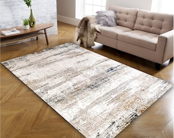 May include: Abstract area rug with a white background and brown, blue, and gray stripes. The rug is on a hardwood floor.