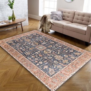 K&ouml;nnte beinhalten: Ein marineblauer Teppich mit traditionellem persischem Design. Der Teppich hat einen roten und cremefarbenen Rand mit komplizierten Blumenmustern.