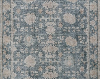 May include: A rectangular area rug featuring a deep slate blue background with a repeating pattern of beige floral motifs. The design includes a wide border with a geometric line detail and a central field filled with symmetrical botanical elements.