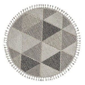 May include: A round rug with a geometric design composed of triangles in various shades of gray. The rug has a fringe of small tassels around the edge. The rug is designed for indoor use.
