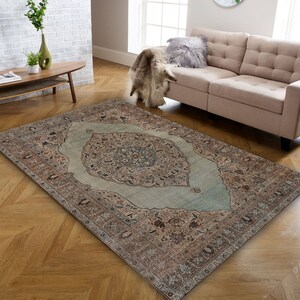 Pu&ograve; includere: Un tappeto vintage con un centro blu chiaro e intricati motivi floreali in tonalit&agrave; di marrone, beige e crema. Il tappeto ha un aspetto vissuto ed &egrave; perfetto per aggiungere un tocco di stile tradizionale a qualsiasi stanza.