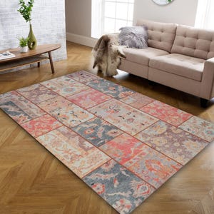 May include: A rectangular patchwork rug with a distressed, vintage look. The rug features a variety of rectangular patterns in shades of pink, blue, and beige. The rug is placed on a hardwood floor.