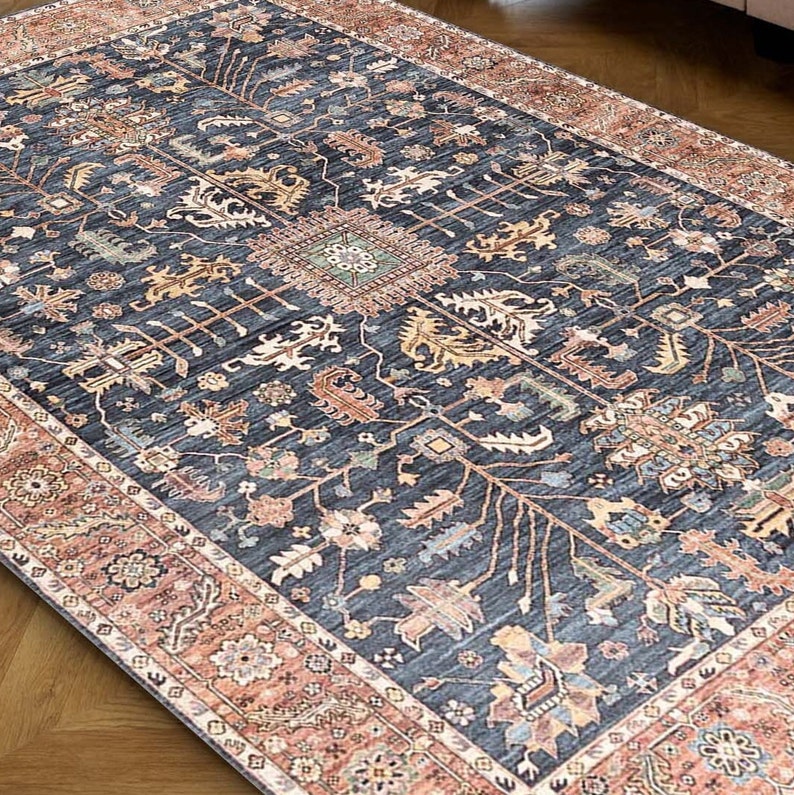 K&ouml;nnte beinhalten: Ein blauer und roter Teppich mit traditionellem Muster. Der Teppich hat einen dunkelblauen Hintergrund mit komplizierten floralen und geometrischen Mustern in Rot-, Orange- und Cremet&ouml;nen.