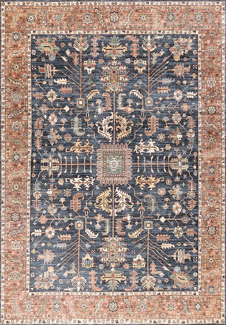 K&ouml;nnte beinhalten: Ein blauer und orangefarbener Teppich mit traditionellem Muster. Der Teppich hat ein zentrales Medaillon und durchgehende, komplizierte Details.
