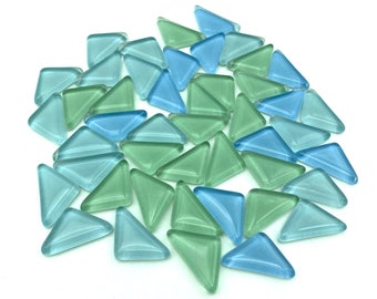 May include: A collection of light blue and green glass triangle tiles. The tiles are arranged in a circular pattern on a white background.