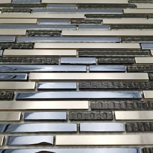 Può includere: Primo piano di una lastra di mosaico con un mix di piastrelle rettangolari argentate, nere e blu. Le piastrelle hanno una finitura lucida e sono disposte in uno schema sfalsato.