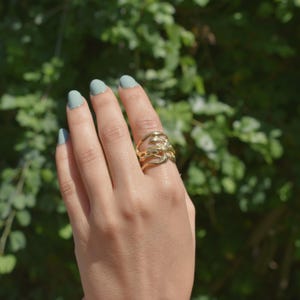 Bold organic gold ring with fluid, sculptural openwork design, handcrafted for a modern artistic style.