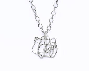 May include: A silver-colored necklace with a pendant featuring a unique, abstract design. The pendant is made of intertwined metal wires, creating a freeform shape. The necklace chain is a simple, linked design.