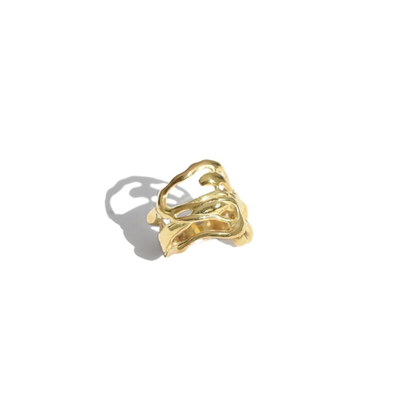 Bold organic gold ring with fluid, sculptural openwork design, handcrafted for a modern artistic style.