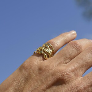 Bold organic gold ring with fluid, sculptural openwork design, handcrafted for a modern artistic style.