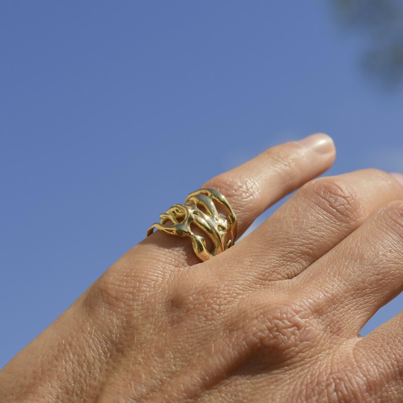 Bold organic gold ring with fluid, sculptural openwork design, handcrafted for a modern artistic style.