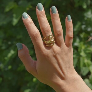 Bold organic gold ring with fluid, sculptural openwork design, handcrafted for a modern artistic style.