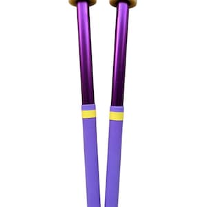 Op de afbeelding: Een paar paarse drumsticks met gele accenten en crèmekleurige koppen.
