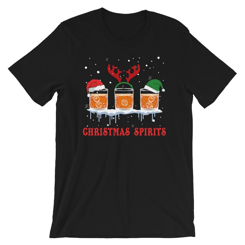 May include: Black t-shirt with a Christmas-themed design featuring three glasses of whiskey with Santa hats and reindeer antlers. The text "Christmas Spirits" is printed below the glasses.