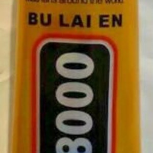 May include: A tube of T-8000 adhesive with a yellow and red label. The label includes the text "BU LAI EN" and "T-8000". The tube has a white nozzle and a silver crimped base. The tube contains 3.7 fl oz (110ml) of adhesive.