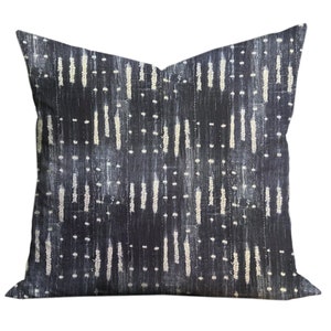 May include: A black and white patterned cushion with a geometric design. The cushion is made of a soft, textured fabric.