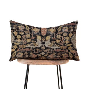 May include: A rectangular pillow with a black background and a floral pattern in shades of brown, yellow, and red. Two stylized birds are featured in the center of the pillow.
