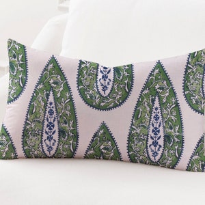 May include: A decorative pillow with a white background and a green and blue paisley pattern.