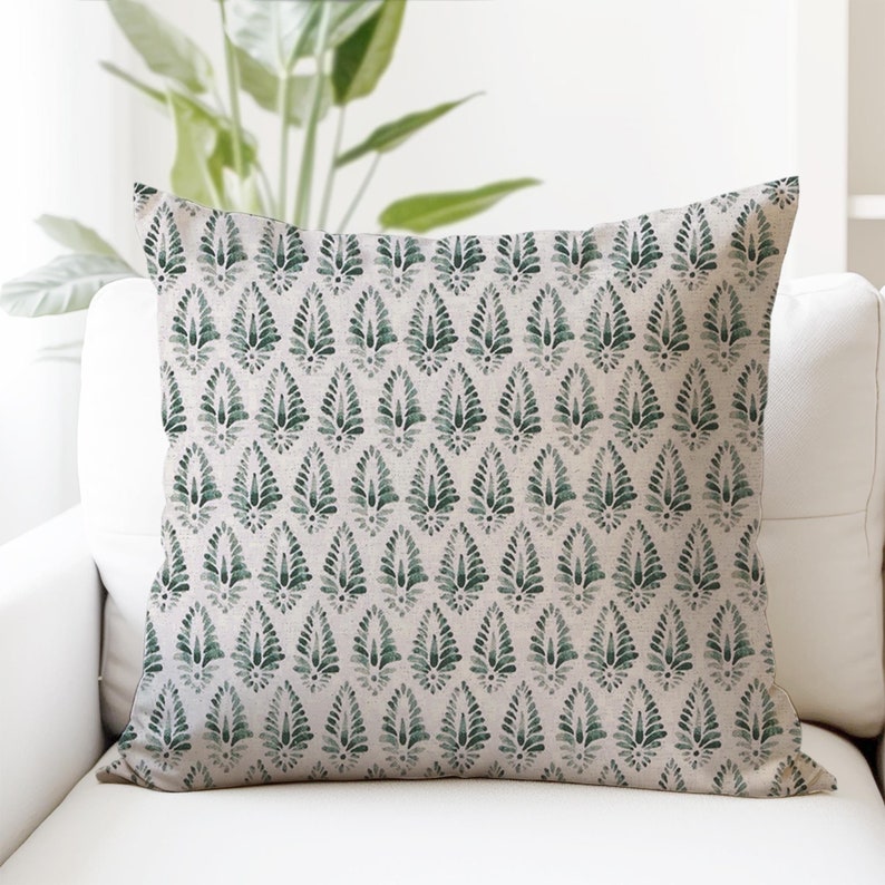 Puede incluir: Una almohada verde y blanca con un patr&oacute;n repetitivo de hojas estilizadas. La almohada est&aacute; hecha de una tela suave y texturizada.